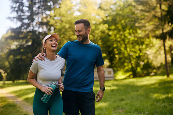 Couple walking together outside in athletic clothes.